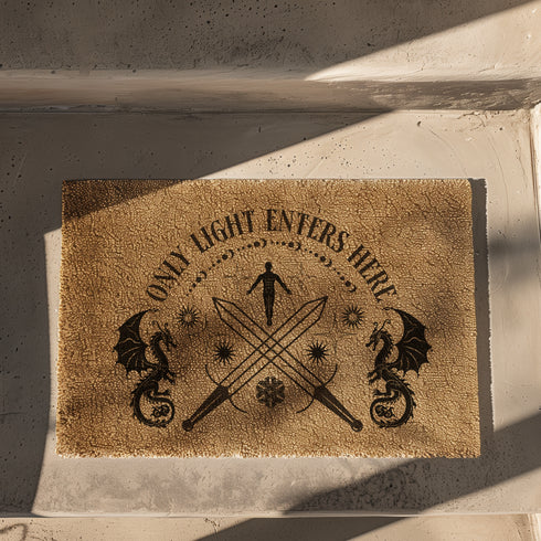 Coir doormat with "Only Light Enters Here" text, two dragons, crossed swords, and a celestial figure, all in dark brown on natural tan background.